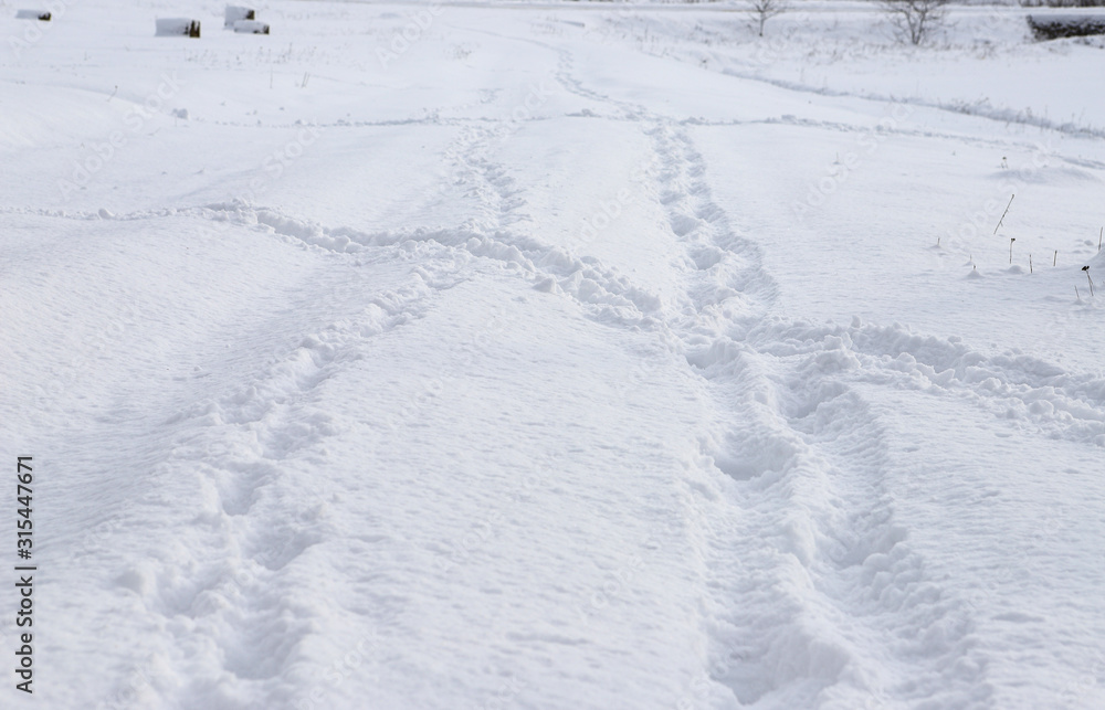 Human footprints in the fresh snow. Traces of people intersect. Beautiful sunny day, fresh snow.