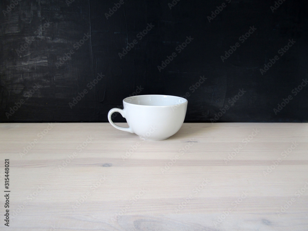 A white mug for tea or coffee with the black and white background A white mug for tea or coffee with the black and white background