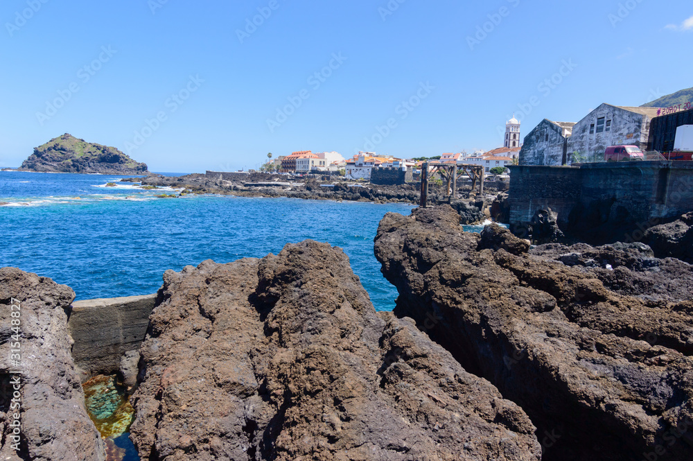 Bay Formed By Volcanic Rocks And An Old Wooden Pier In Hell In Garachico. April 14, 2019. Garachico, Santa Cruz De Tenerife Spain Africa. Travel Tourism Street Photography.