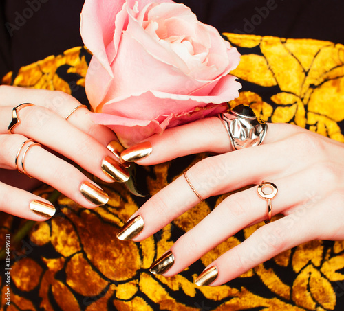 woman hands with golden manicure lot of jewelry on fancy dress closeup beauty concept photo