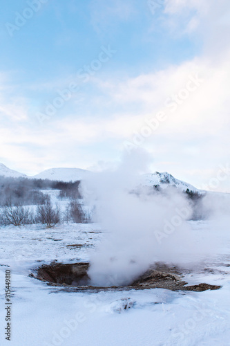 An erupting soaring geyser in the Valley of Geysers. Magnificent Iceland in the winter. © Kate