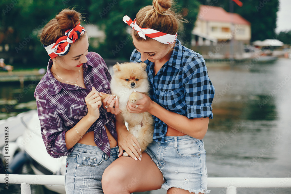 Elegant pin up ladies in a shirt in a cell. Girl with cute little dog. Women standing near water Elegant pin up ladies in a shirt in a cell. Girl with cute little dog. Women standing near water