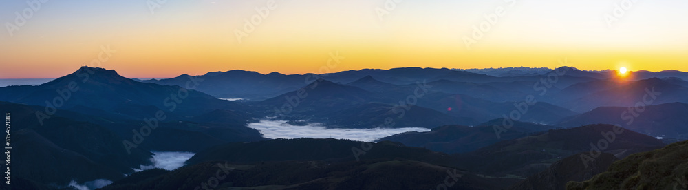 The sun rises with mists over the Pyrenees mountains in Euskadi and Navarra, from the Aiako Harriak Natural Park