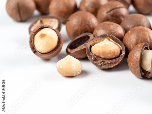 Set of macadamia nuts on white background with copy space. Set of macadamia nuts - whole unshelled, with open shells, and shelled. Isolated on white. Copy space for text.