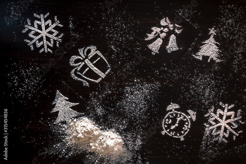 Christmas tree shapes surrounded by powdered sugar on a slate