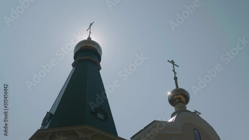 Top of church with golden dome in backlit. Blue sky on background. Bottom view photo