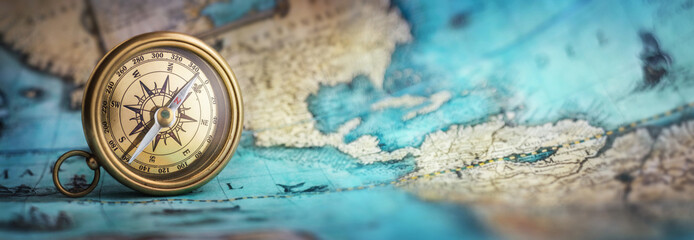 Magnetic old compass on world map.Travel, geography, navigation, tourism and exploration concept background. Macro photo. Very shallow focus.