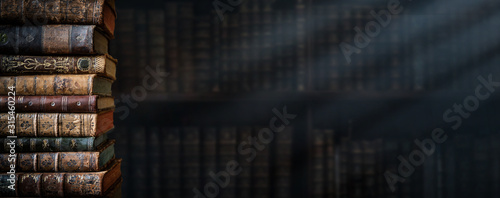 Old books on wooden shelf and ray of light. Bookshelf history theme grunge background. Concept on the theme of history, nostalgia, old age. Retro style. photo