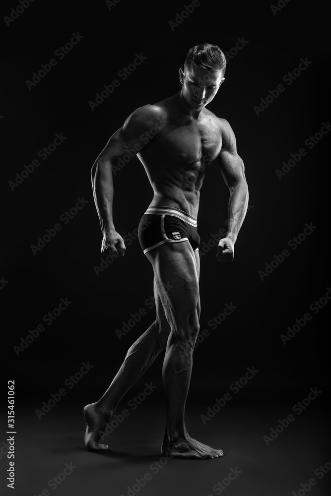 Bodybuilder man posing, showing perfect abs, houlders, biceps, triceps, chest Bodybuilder man posing, showing perfect abs, houlders, biceps, triceps, chest