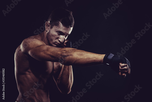 MMA Fighter Preparing Bandages For Training. Dark background