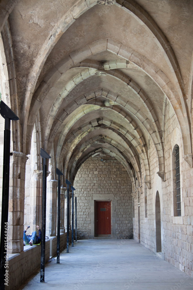 Un hombre escucha música en un pasillo de arquitectura gótica