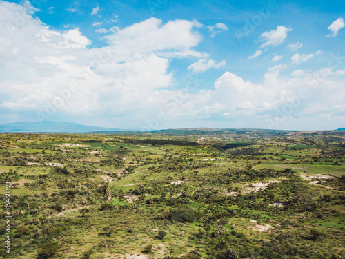 Aerial view of green field with mountains in the background