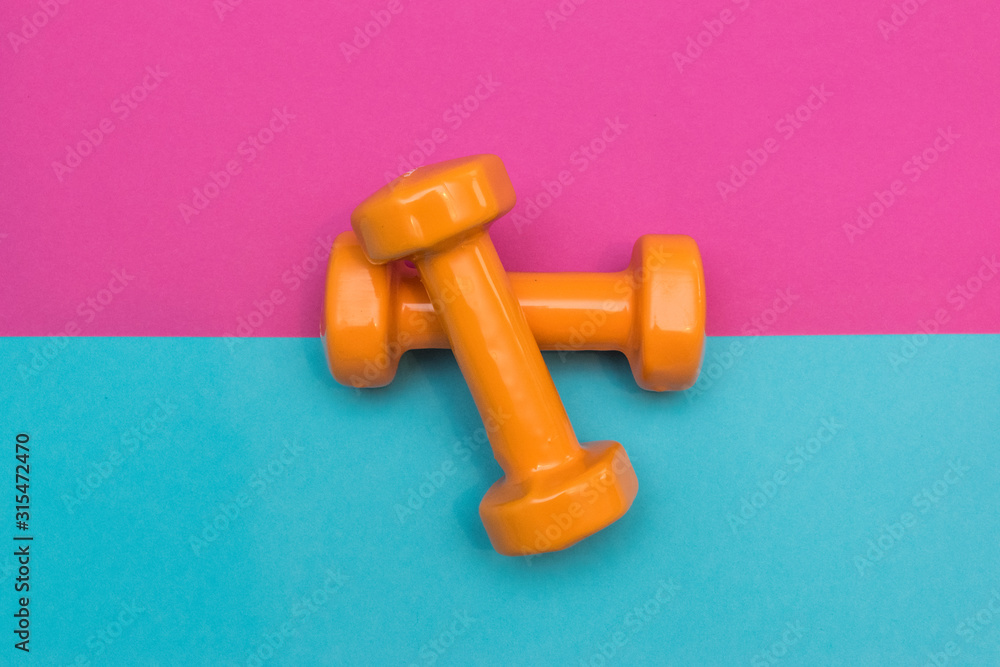Two dumbbells for sport on the pink blue background. Two dumbbells for sport on the pink blue background.