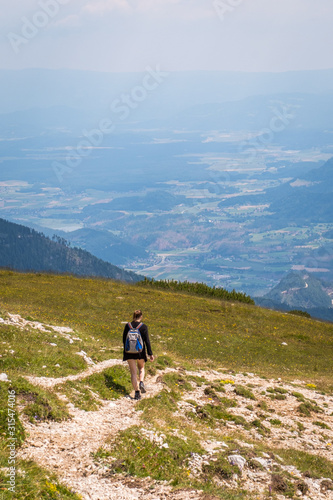 Hiking woman with view from mountain Hochobir to valley Jauntal photo
