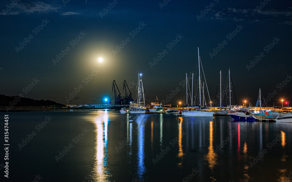 Parked boats under the full moon