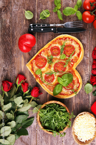 pizza Heart shaped margherita with tomatoes and mozzarella vegetarian. Food concept of romantic love pizza for Valentines Day.