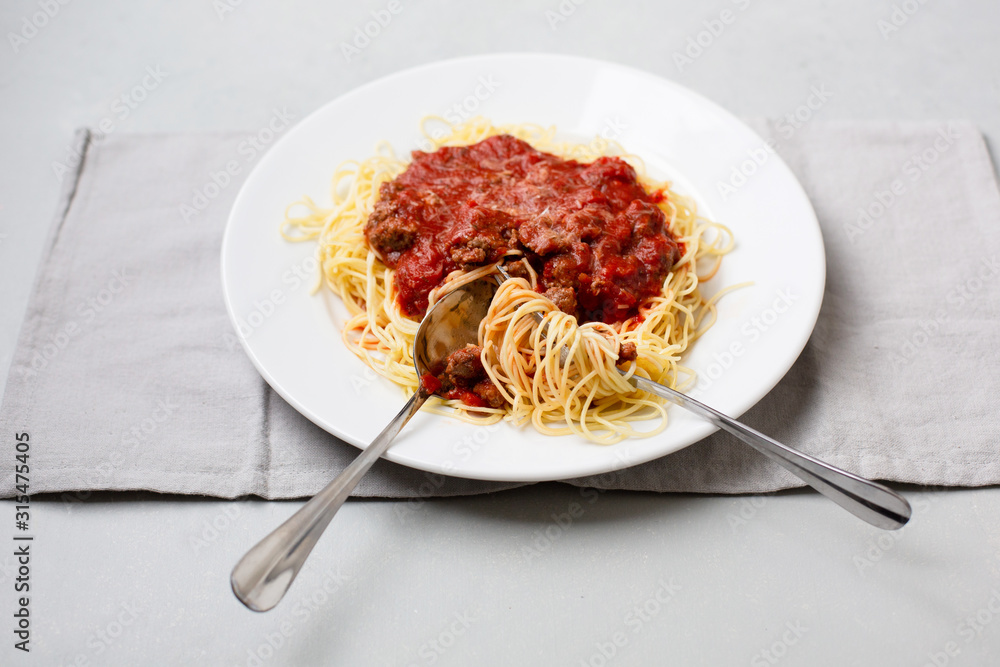 Homemade Spaghetti with Meat Sauce in White Plate on Neutral Gray Background