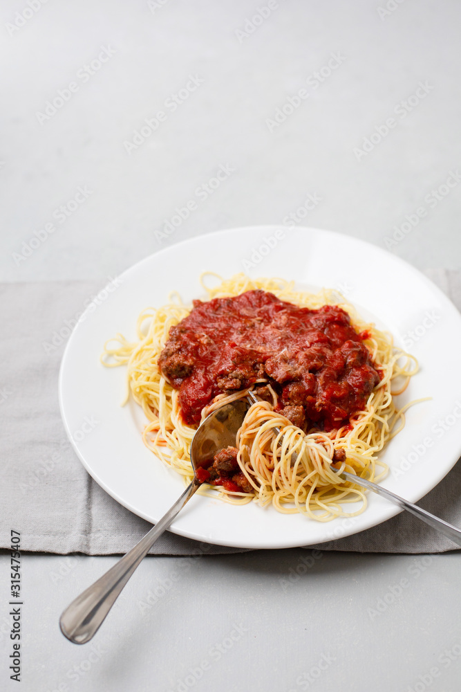 Homemade Spaghetti with Meat Sauce in White Plate on Neutral Gray Background Homemade Spaghetti with Meat Sauce in White Plate on Neutral Gray Background