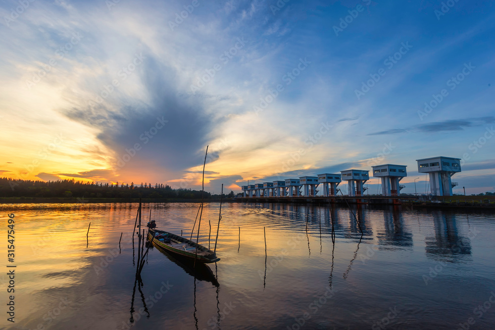 A Thai folk fishing boat made of wood, moored on the banks of the river in the morning near the Uthokvibhajaprasid barrage in Pak Phanang District, Nakhon Si Thammarat Province, Thailand.