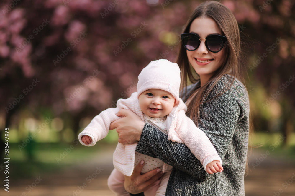Portrait of mother and her little baby girl. Beautiful mom and cute baby.  Mother hud her daughter. Baby dressed in peanch colour hat and smile Stock  Photo | Adobe Stock