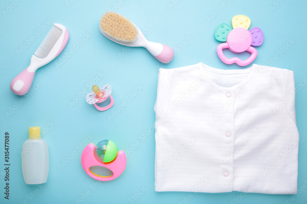 Baby clothes with a shower accessories on a blue background