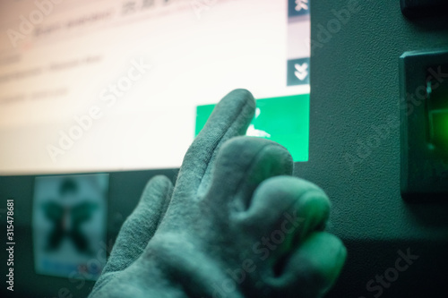 Women's gloved hand presses on the touch screen infokiosk night