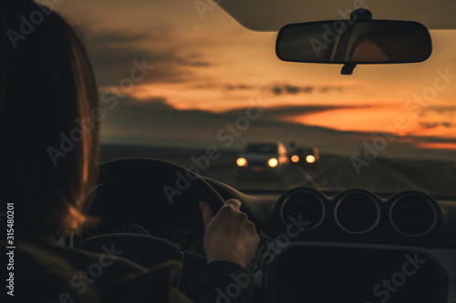 Fotografie Woman driving car in dusk