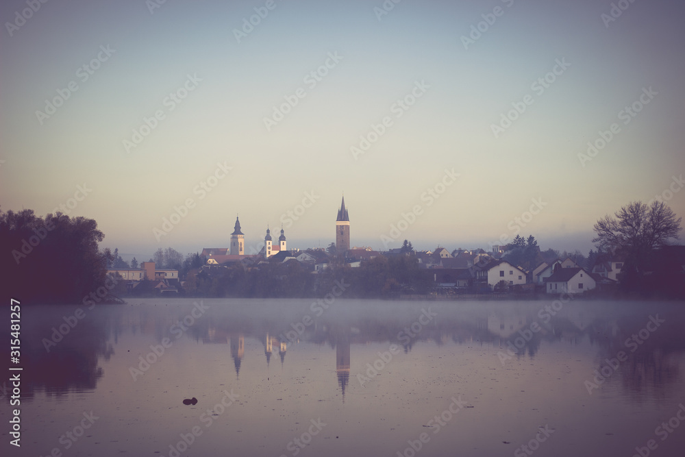 Naklejka premium Reflection of a Central Bohemian town in a pond