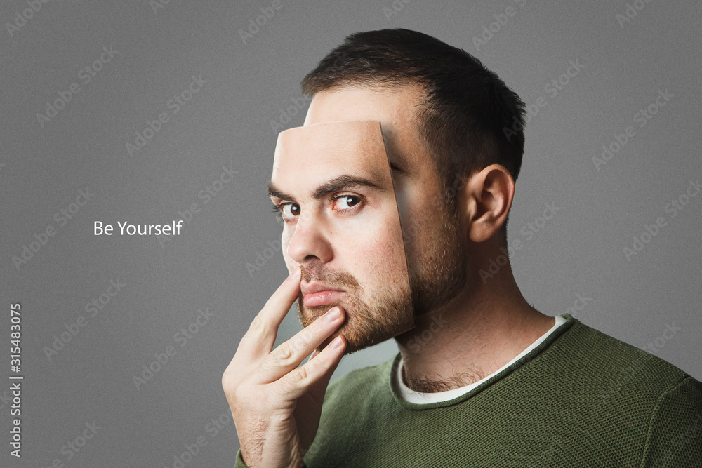 Be Yourself. Handsome man holds a mask of his face. Copy space. Be Yourself. Handsome man holds a mask of his face. Copy space.