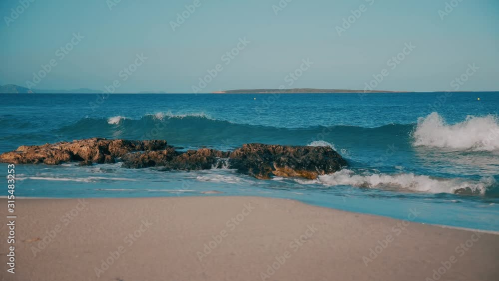 Transparent clean sea waves break on the rocks on Formentera island beach Transparent clean sea waves break on the rocks on Formentera island beach