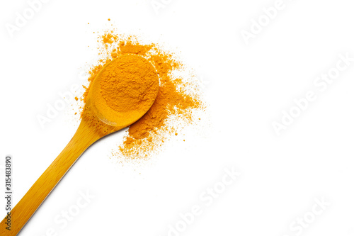 Dry turmeric powder and wooden spoon on  isolated white background.Close-up of powder orange color turmeric.top view and copy space