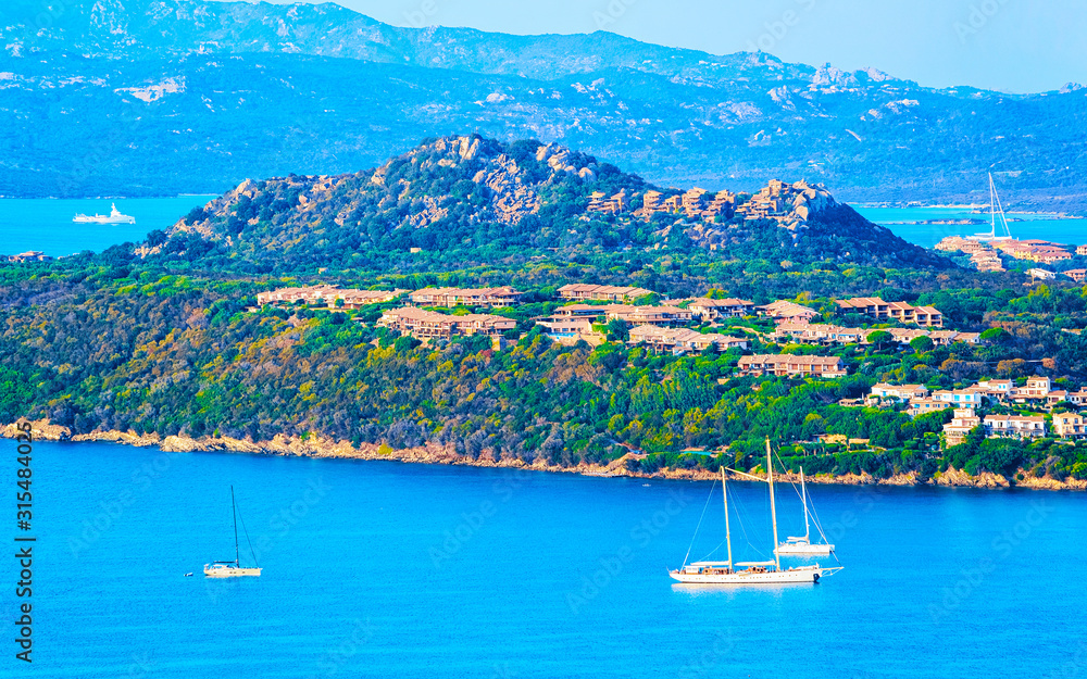 Obraz premium Landscape and scenery of Golfo Aranci atSardegna island in Italy in summer. Sassari province near Olbia and Cagliari. In Mediteranean sea. Yachts, boats and ships. Mixed media.