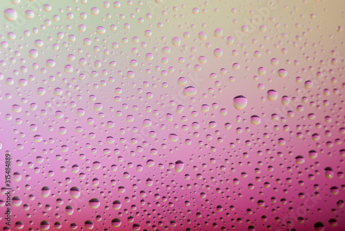 closeup of water droplets on a glass. Rainbow background  colorful abstract pattern.