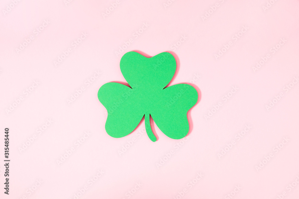 St.Patrick 's Day composition. Decoration paper green clovers or shamrocks on pastel pink background. Flat lay, top view, copy space