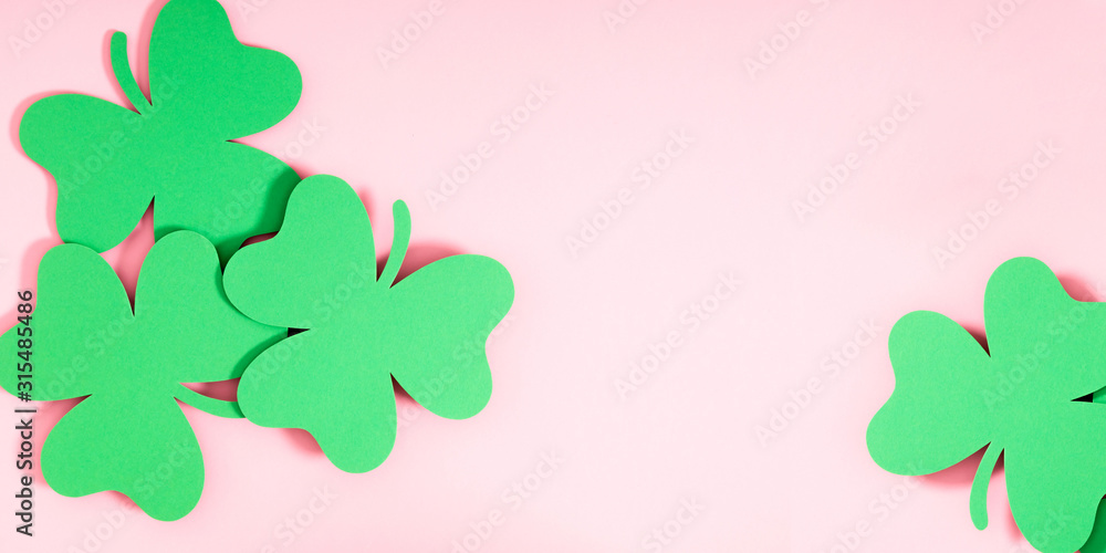 St.Patrick 's Day composition. Decoration paper green clovers or shamrocks on pastel pink background. Flat lay, top view, copy space St.Patrick 's Day composition. Decoration paper green clovers or shamrocks on pastel pink background. Flat lay, top view, copy space