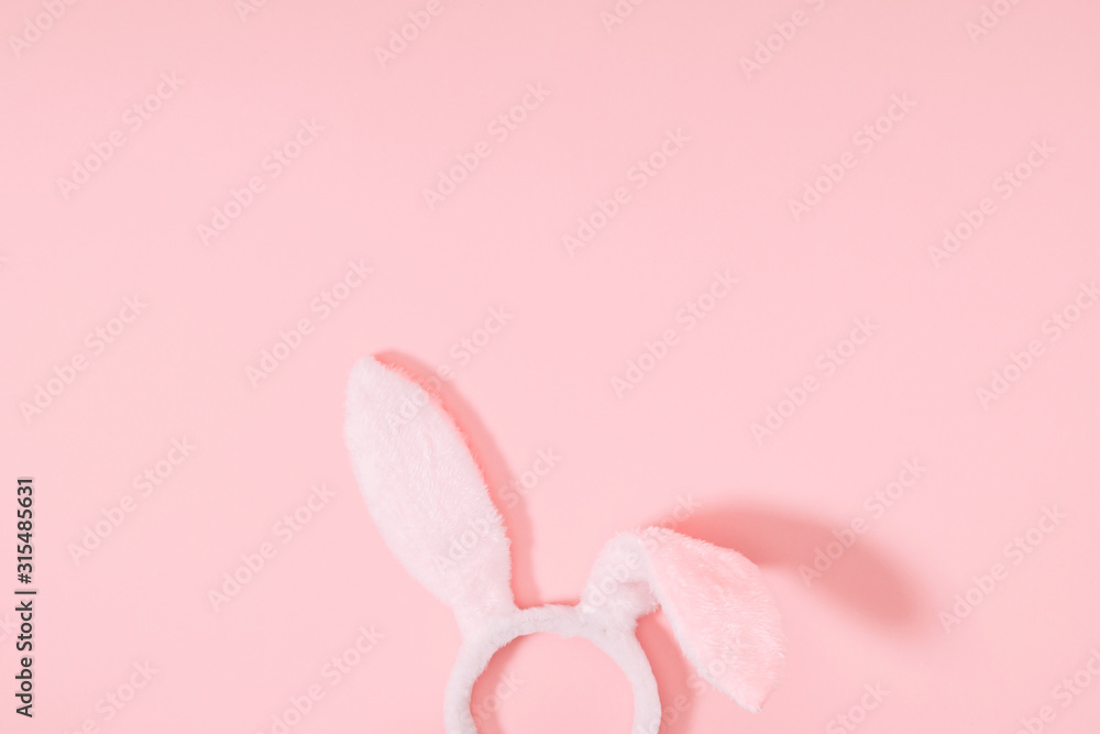 Easter pink minimal composition. Easter decoration, bunny ears on pastel pink background. Flat lay, top view, copy space