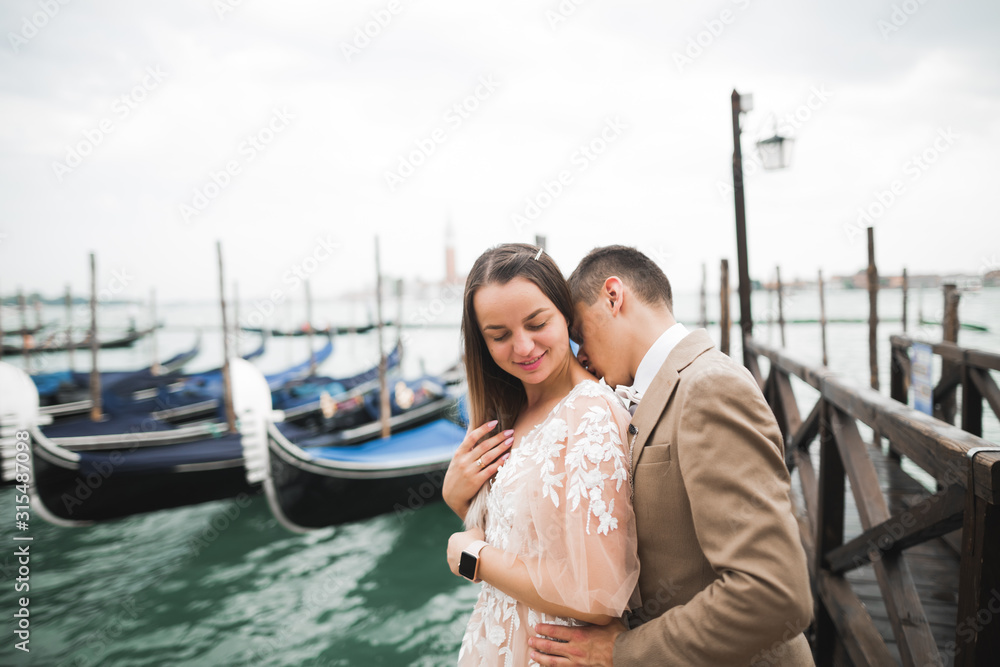 Wedding couple on the nature is hugging each other. Beautiful model girl in white dress. Man in suit.Venice, Italy