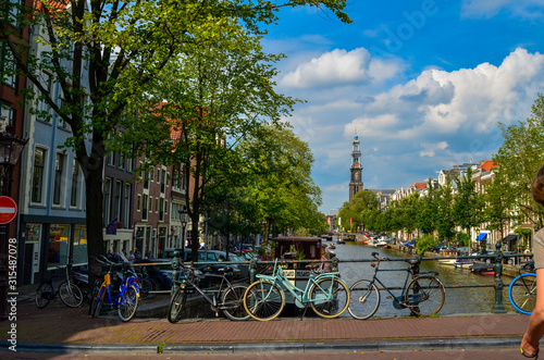 Amsterdam, Holland, August 2019. From a bridge you can see the bell tower of the Western Church, in Dutch "Westerkerk". Outside the church a statue was placed in memory of Anna Frank.