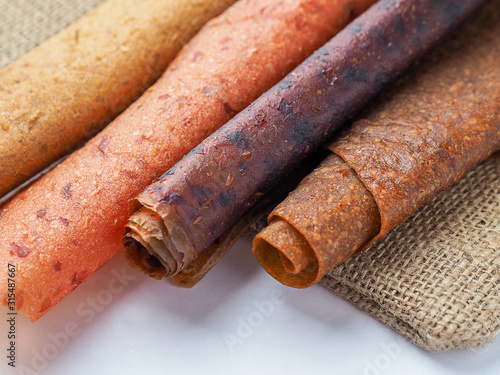 Colorful fruit leather rolls on white background