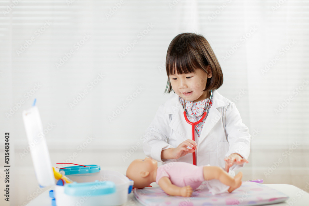 toddler girl pretend play doctor role at home against white background toddler girl pretend play doctor role at home against white background