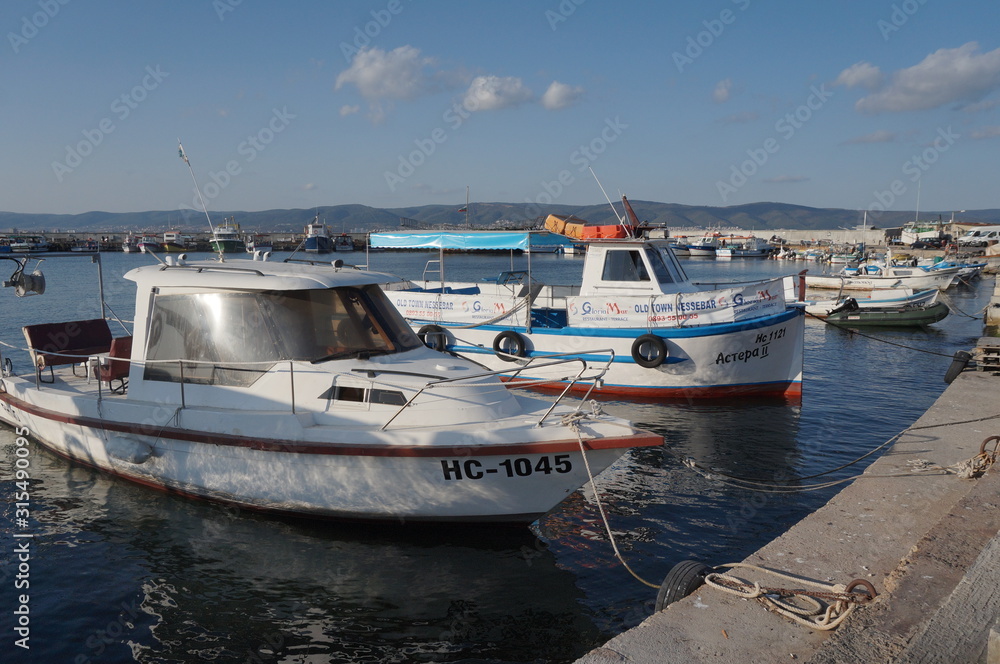 Fishing boats moored on the pier, summer day.