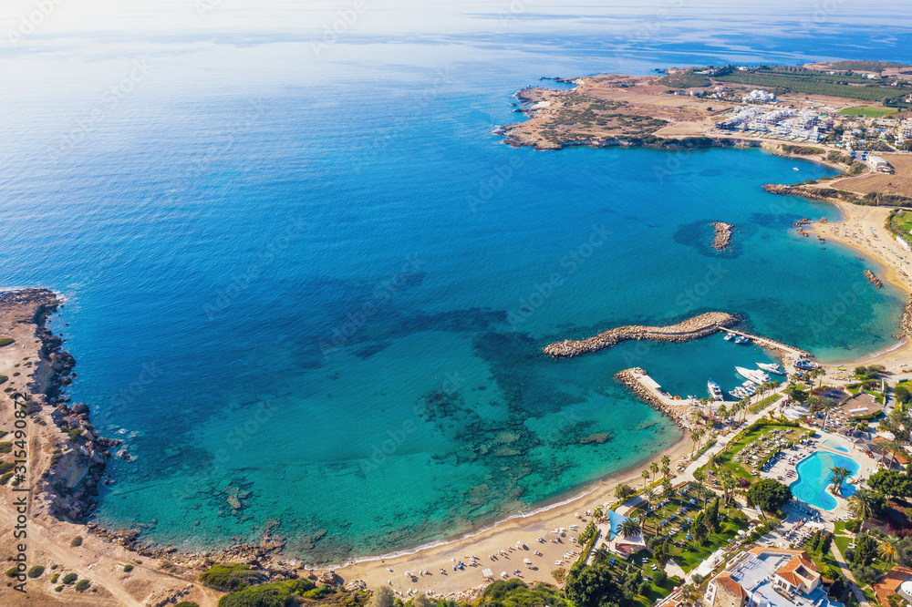 Summer vacation in Cyprus island. Aerial view of bay with clear blue sea water and seaside with sand beach.