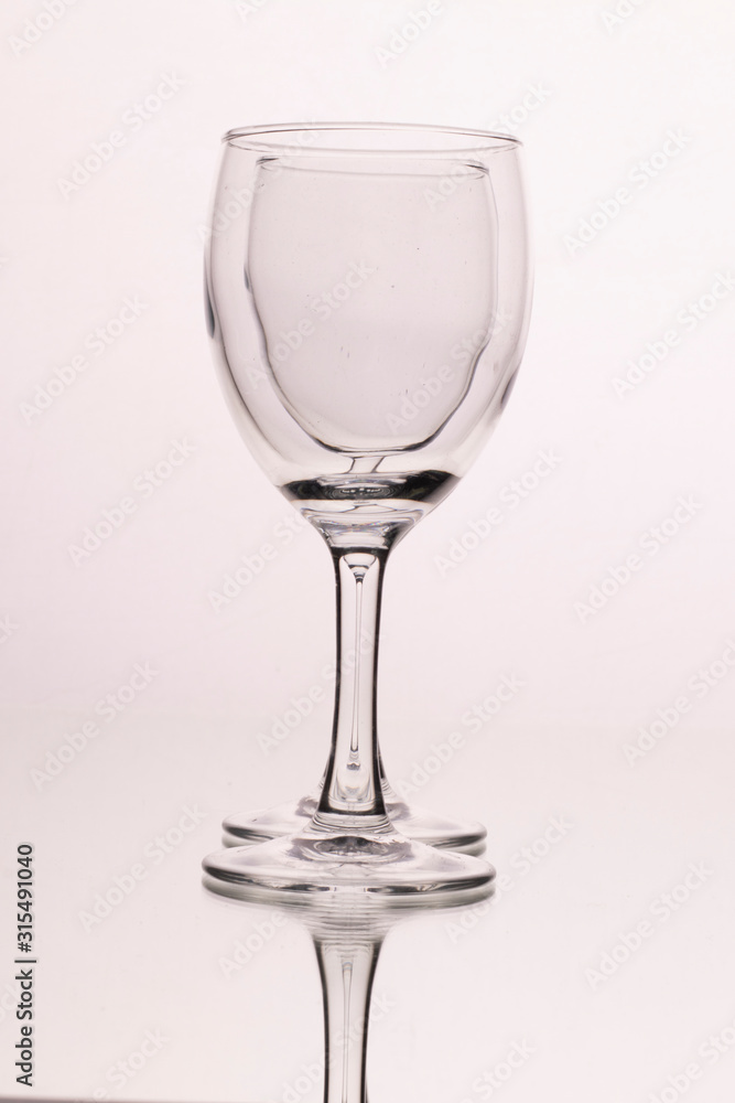 Two wine glasses isolated on a white background. The optical effect of a glass in a glass Two wine glasses isolated on a white background. The optical effect of a glass in a glass