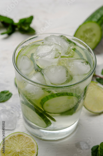 Infused water on a glass. Detox water mix of cucumber, lemon, lime and mint.