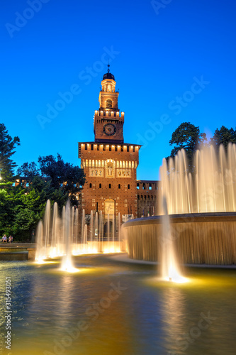 The Sforza Castle with the fountain illuminated at blue hour, Milan, Italy