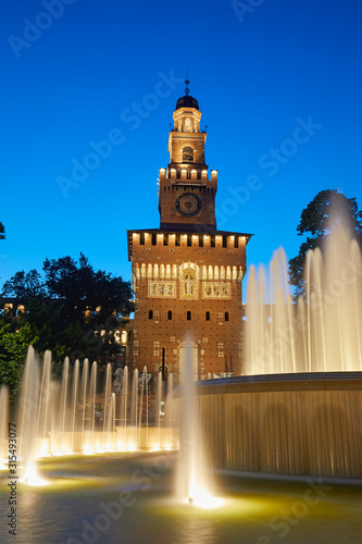 The Sforza Castle with the fountain illuminated at blue hour, Milan, Italy