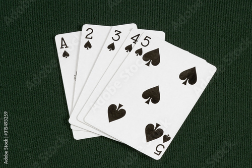 Poker Straight Flush spades A 2 3 4 5 on green card table top