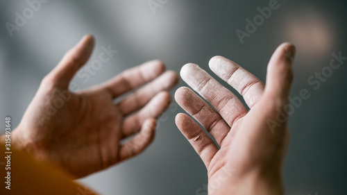 Hände von jungem Mann in Kletterhalle mit Kreide Magnesium