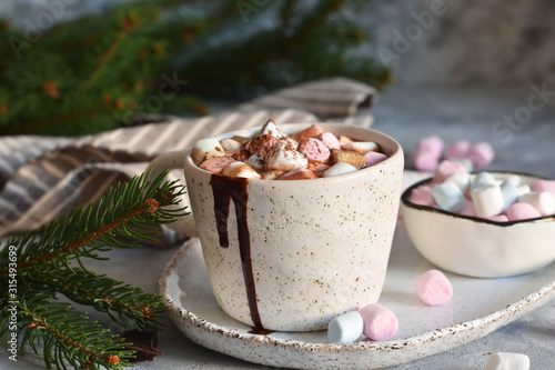 Hot chocolate with marshmallows and muffin on a concrete background.