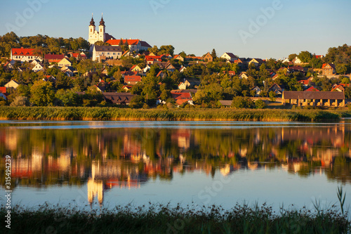 Tihany village and the Benedictian abbey in warm sunset colors with the inner lake in the front and a beautiful refletion on water at lake Balaton in Hungary photo